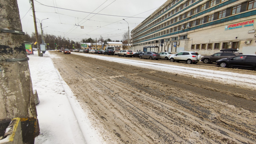 Загрязненный снег на дороге в городе зимним днем