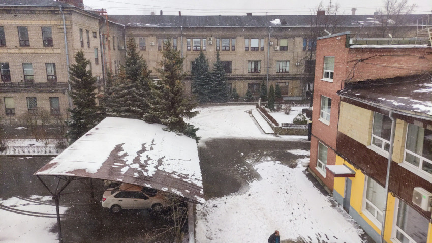 Падающий снег на дворе около жилых домов