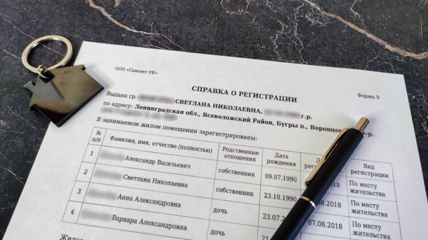 Справка о регистрации с ключом в форме дома и ручкой на столе