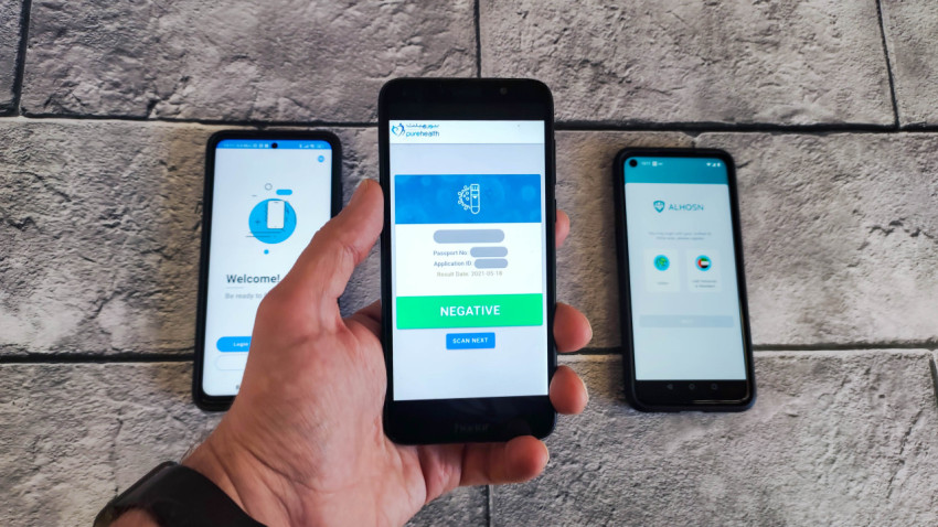 Рука держит смартфон с результатом теста на COVID-19 в ОАЭ