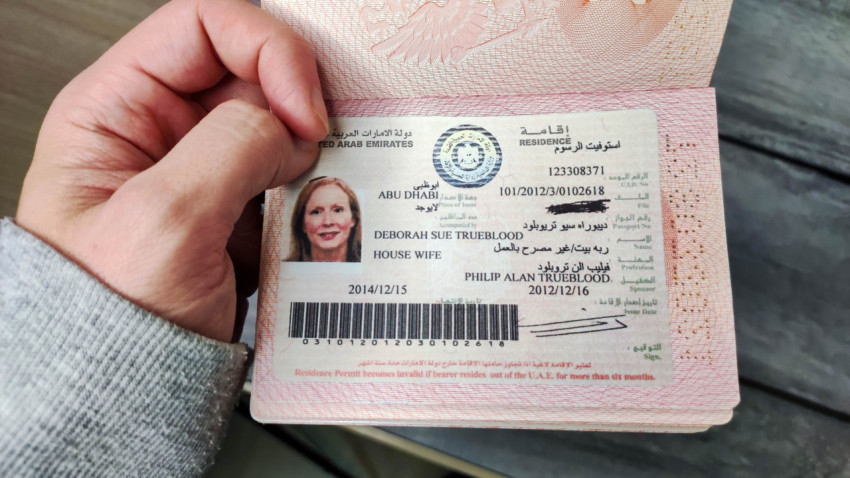 Паспорт с видом на жительство ОАЭ, удерживаемый рукой