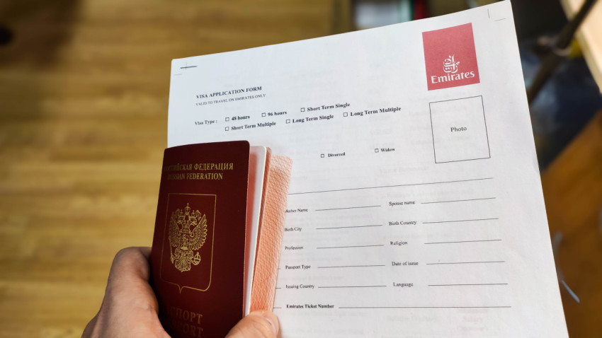 Визовая анкета Emirates и заграничный паспорт в руке
