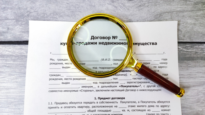 Лупа увеличивает надпись на договоре недвижимости