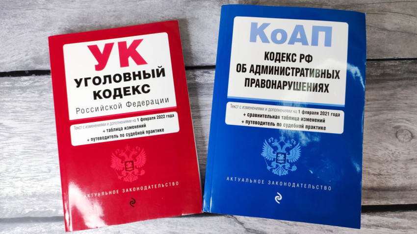 Уголовный и административный кодексы РФ на деревянной поверхности
