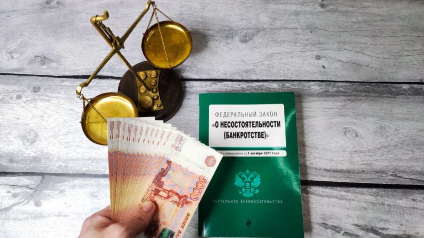 Купюры и закон о банкротстве рядом с весами Фемиды