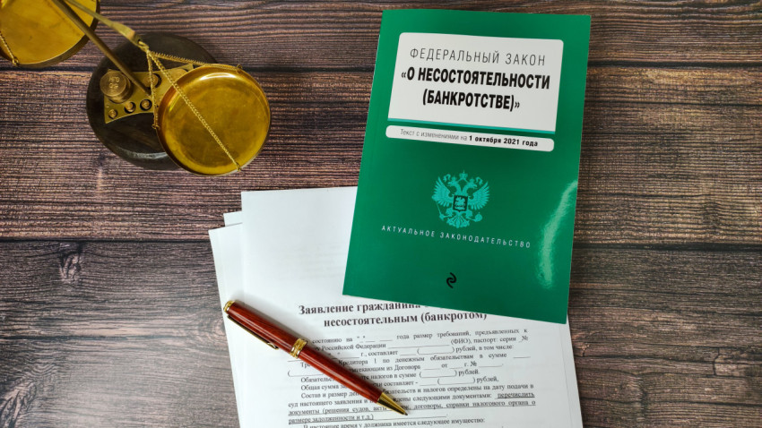 Федеральный закон о банкротстве рядом с весами и документами