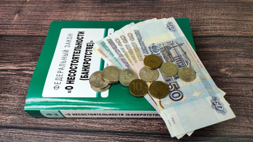 Закон о банкротстве и российские деньги на деревянной поверхности