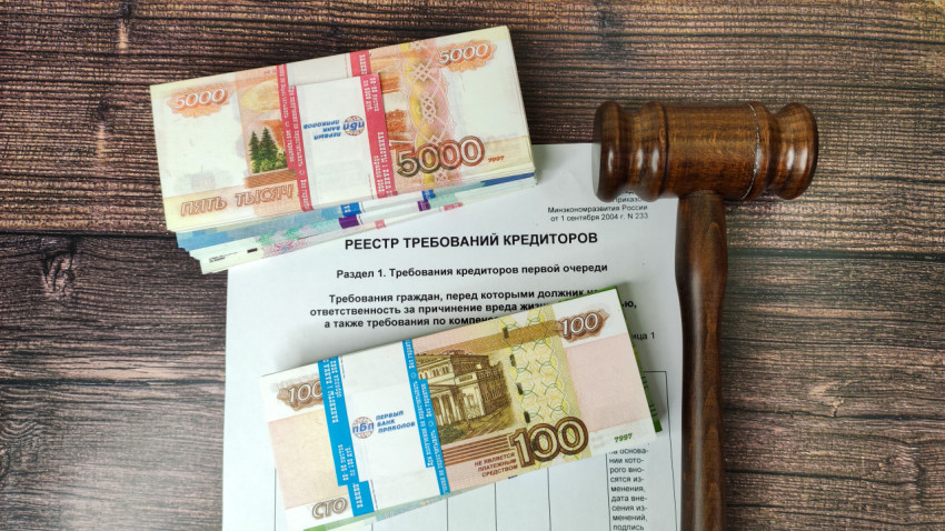Реестр требований кредиторов и судейский молоток на фоне купюр