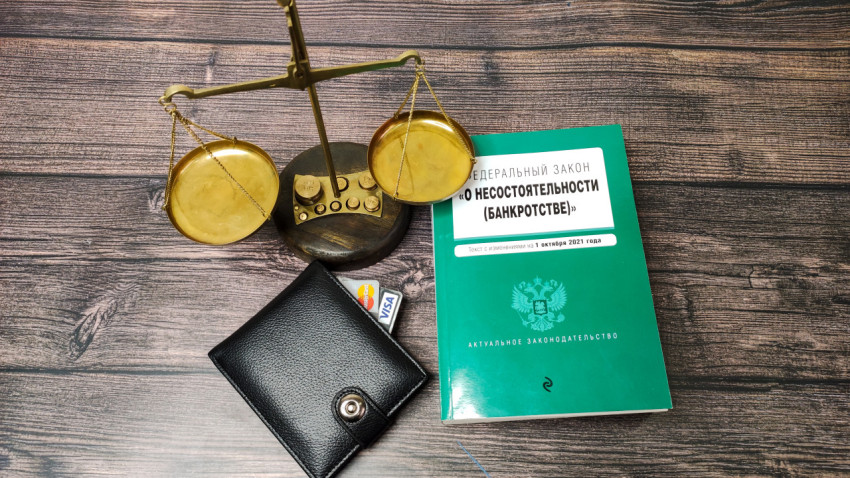 Весы правосудия и закон о несостоятельности на столе