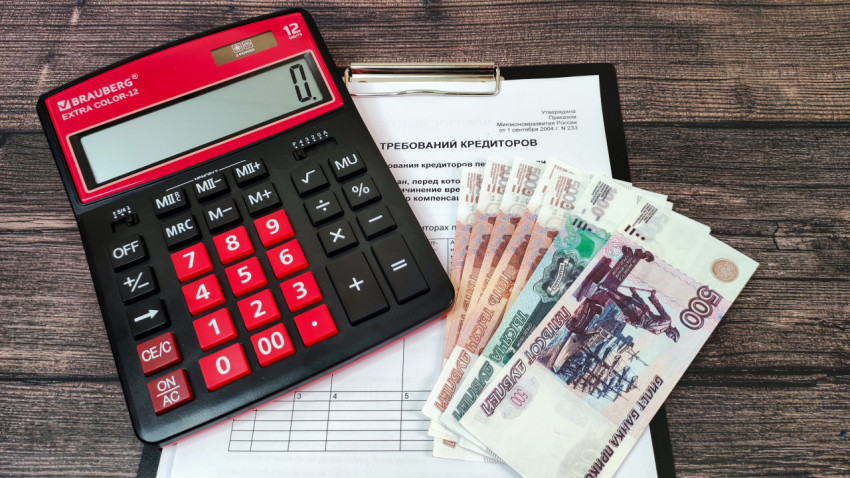 Калькулятор и наличные деньги на фоне реестра требований кредиторов