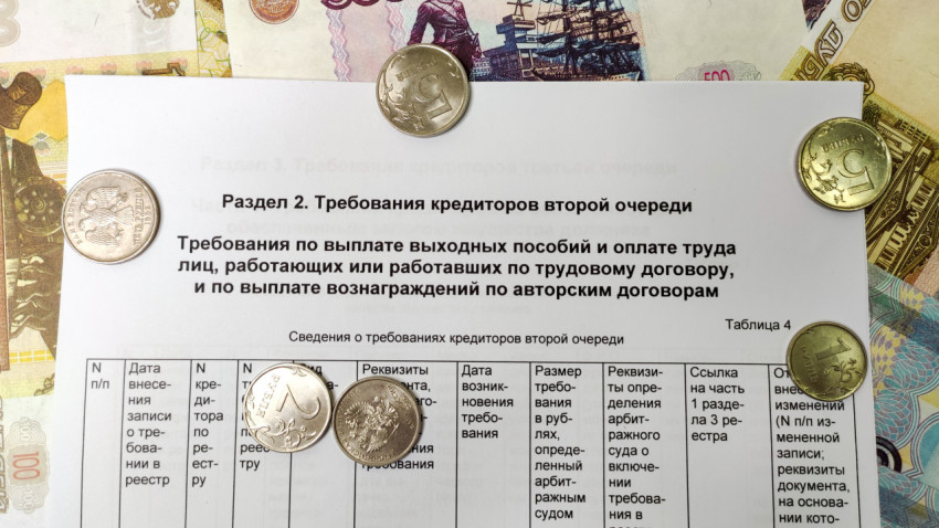 Монеты и банкноты на фоне таблицы требований кредиторов второй очереди