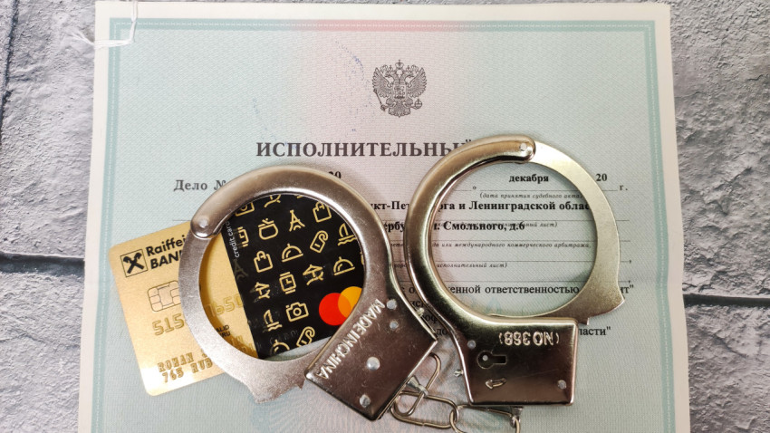 Наручники с банковскими картами на исполнительном листе