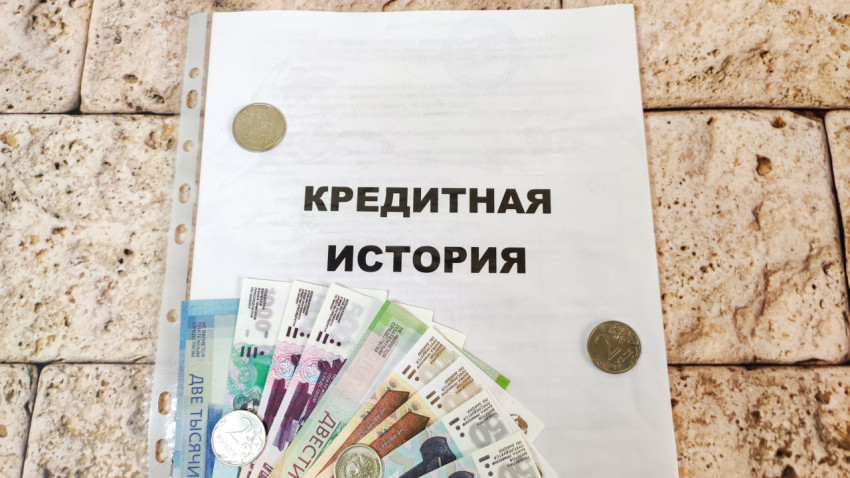 Папка с надписью «Кредитная история» и деньги на обложке