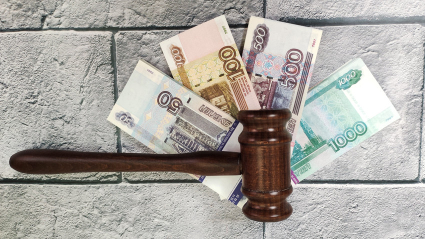 Молоток судьи и рубли на фоне серой плитки