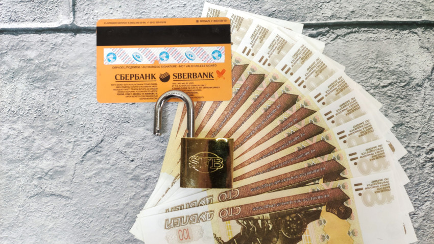 Замок на банковской карте и веере из купюр
