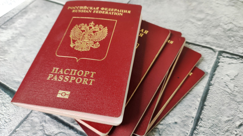 Куча загранпаспортов граждан РФ на каменном фоне