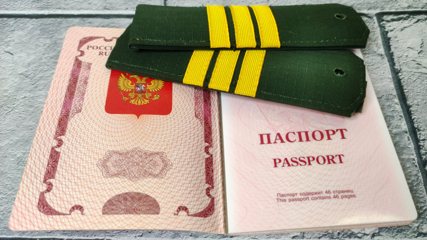 Заграничный паспорт РФ и погоны на фоне страницы с гербом
