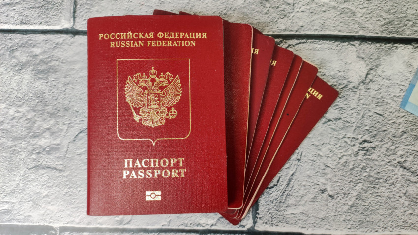 Стопка биометрических загранпаспортов РФ на сером фоне