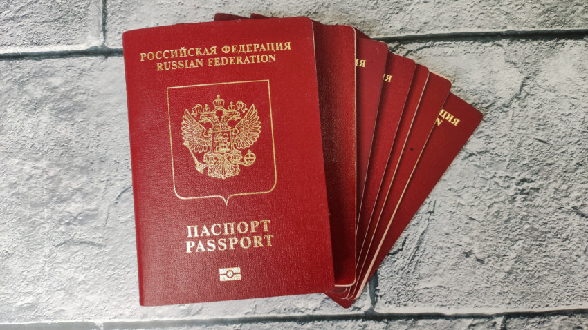 Загранпаспорта граждан РФ в веере на фоне серой поверхности