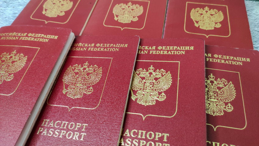 Несколько загранпаспортов РФ на фоне столешницы крупным планом