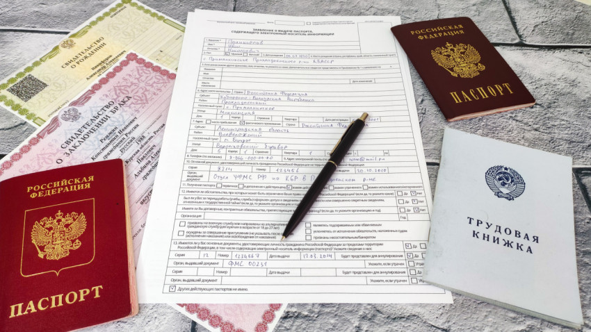 Бланк заявления на загранпаспорт и документы гражданина РФ на сером фоне