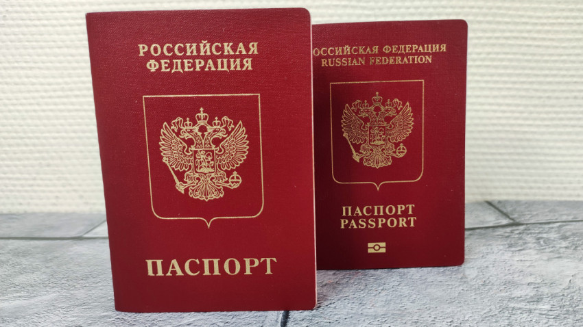 Два загранпаспорта России на фоне светлой стены