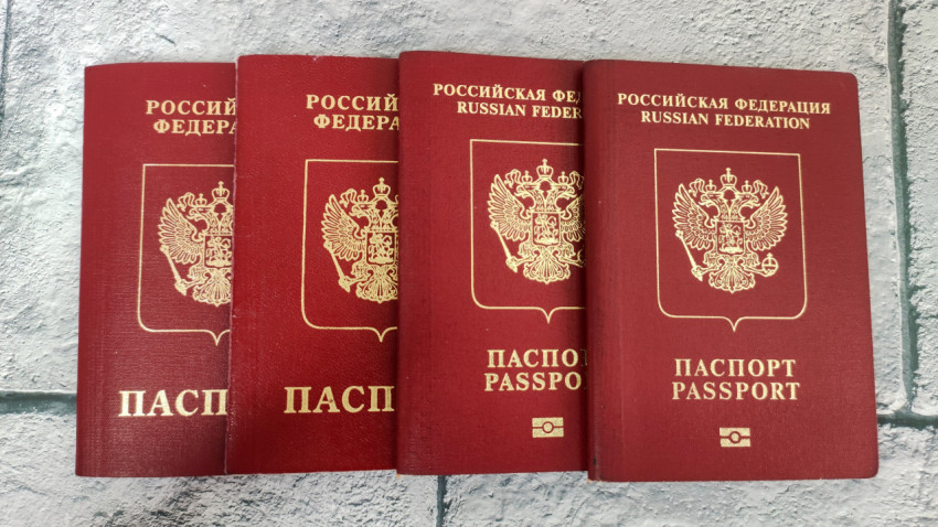 Четыре заграничных паспорта России в ряд на серой плитке