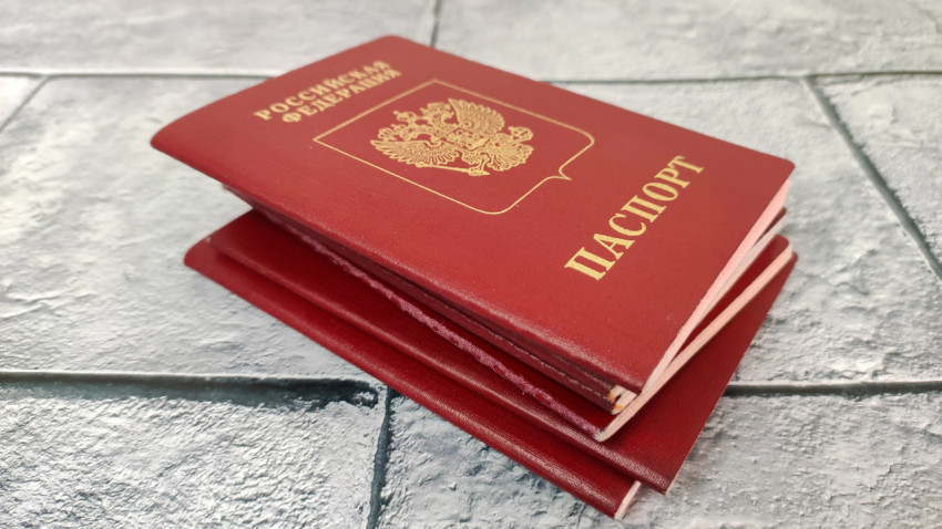 Красный загранпаспорт РФ поверх нескольких паспортов