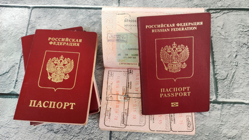 Загранпаспорт РФ на фоне открытых виз и стопки паспортов