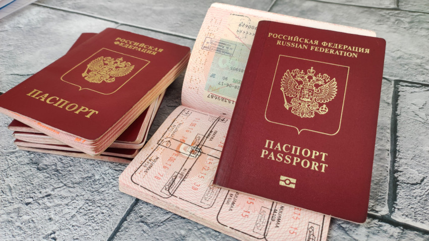 Загранпаспорт с биометрическим значком на фоне виз и штампов