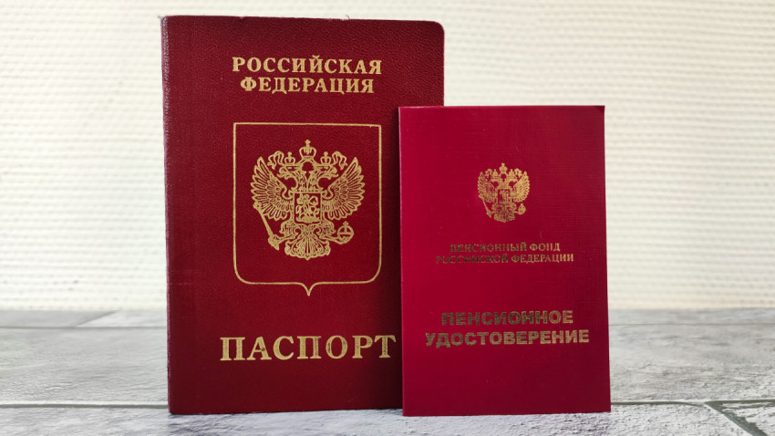 Загранпаспорт старого образца и пенсионное удостоверение на светлом фоне
