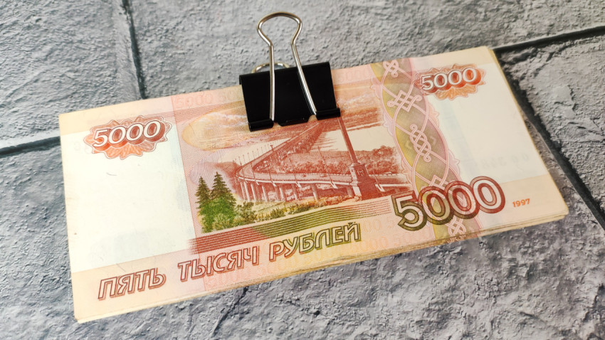 Пачка купюр 5000 рублей с канцелярским зажимом с зажимом на плитке
