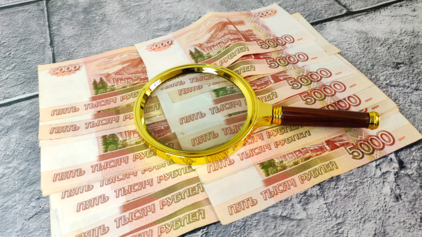 Проверка банкнот с помощью увеличительного стекла