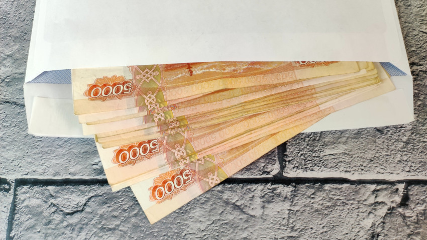 Купюры 5000 рублей в почтовом конверте на сером фоне