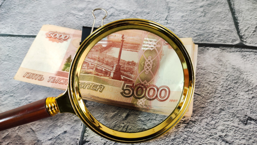 Крупный фрагмент купюры 5000 рублей под лупой