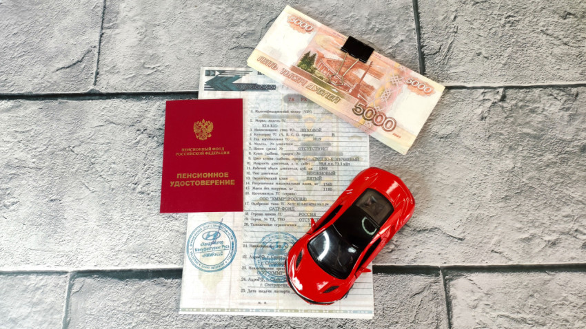 Паспорт транспортного средства и деньги на плиточном фоне