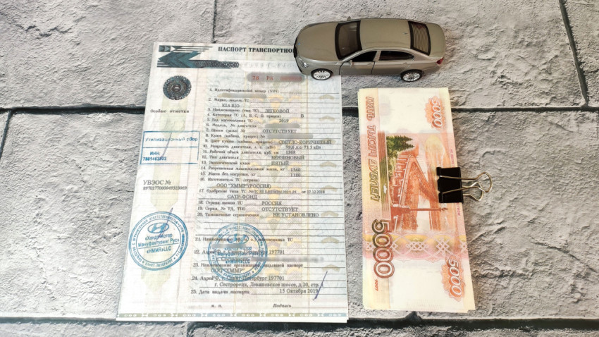 Паспорт автомобиля с моделью машины и денежной купюрой