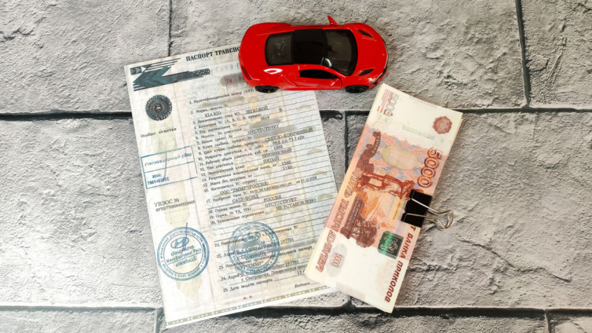 Игрушечный автомобиль, ПТС и купюры на фоне серой плитки