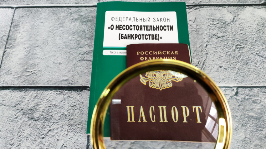 Федеральный закон о банкротстве и паспорт под увеличительным стеклом