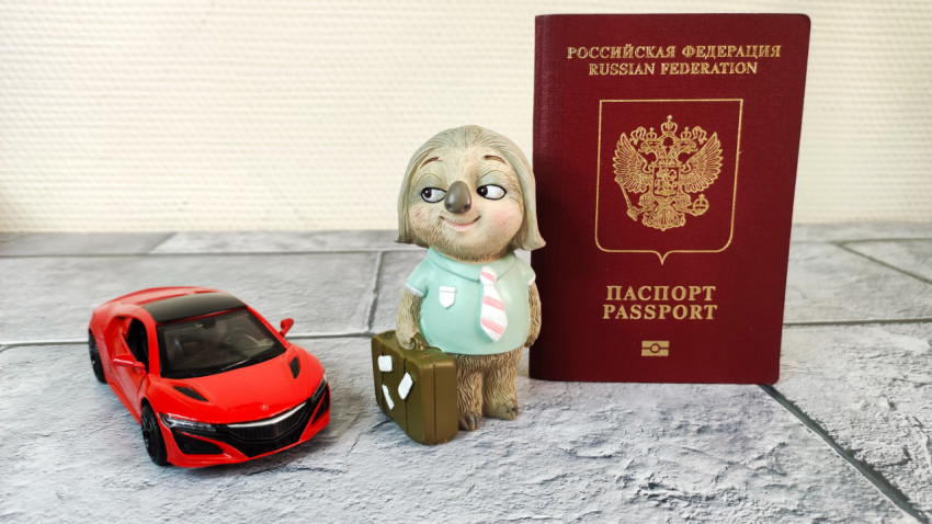 Паспорт гражданина РФ рядом с фигуркой и моделью автомобиля
