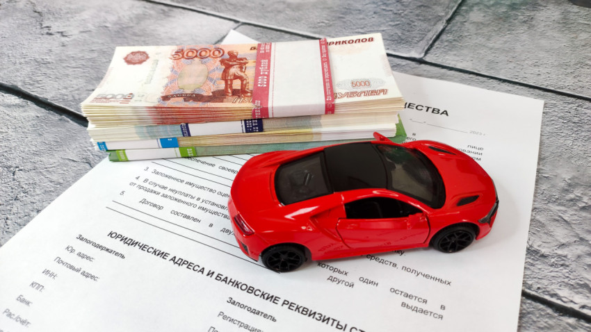 Купюры и игрушечная машина на договоре залога имущества