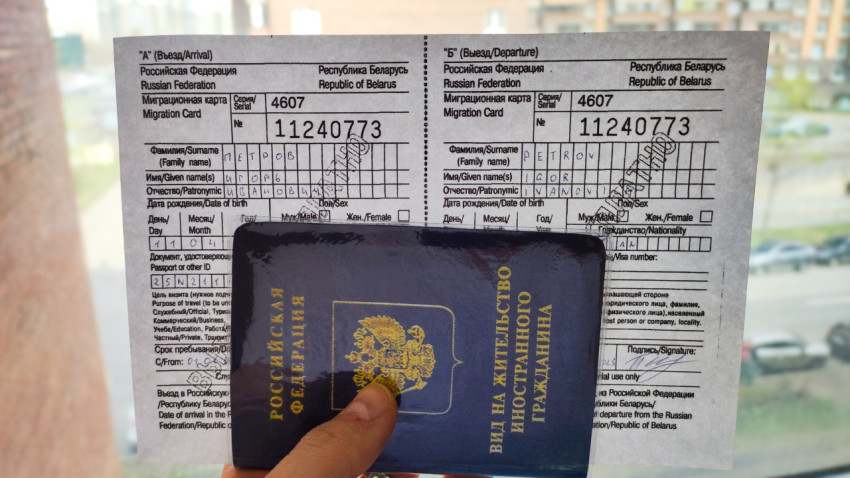 Миграционная карта с видом на жительство в руке