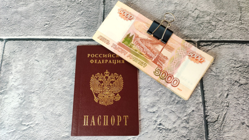 Паспорт РФ и пачка купюр с зажимом на фоне плитки