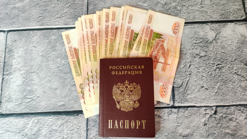 Паспорт и веер из купюр на сером фоне
