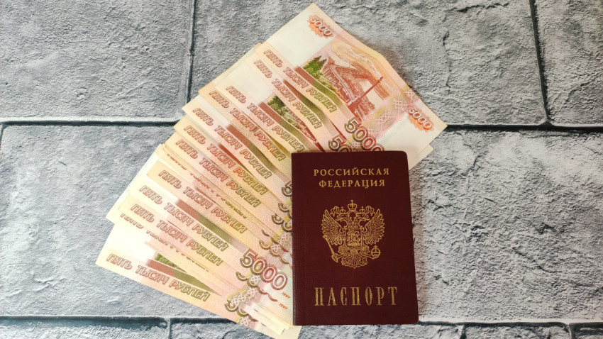 Паспорт среди купюр номиналом 5000 рублей