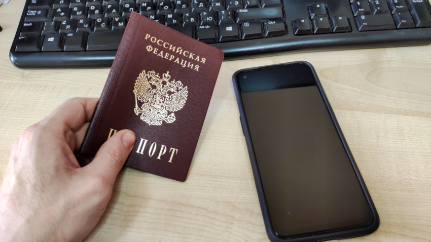 Паспорт и смартфон на фоне клавиатуры на столе
