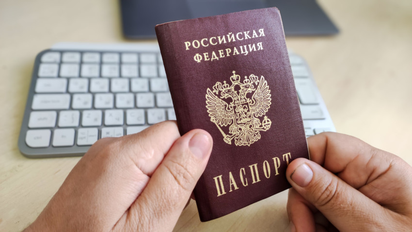 Паспорт гражданина России в руках на фоне клавиатуры