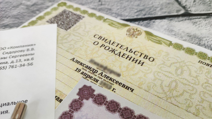 Свидетельство о рождении рядом с заявлением на пособие и свидетельством о смерти