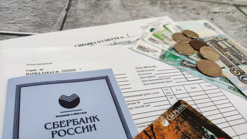 Сберкнижка, наличные деньги и справка о смерти на фоне наряда-заказа