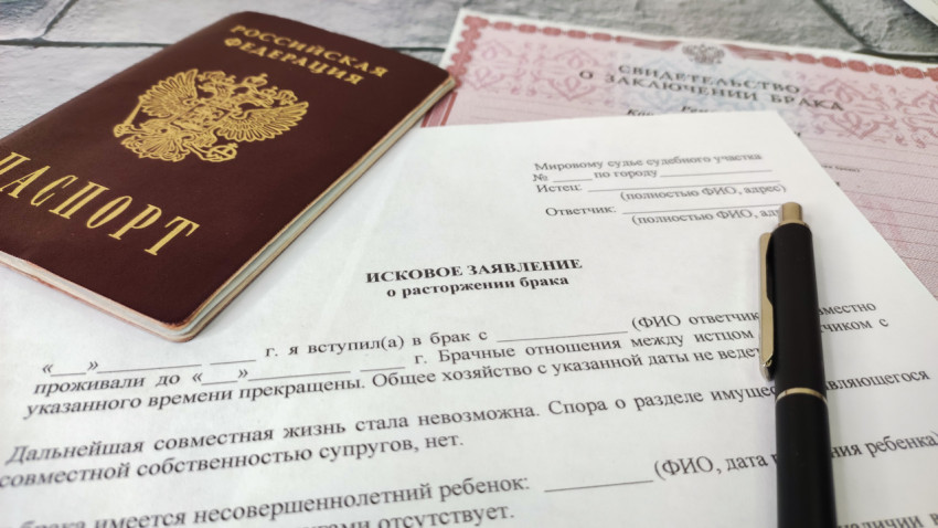 Паспорт и исковое заявление о расторжении брака на столе рядом со свидетельством